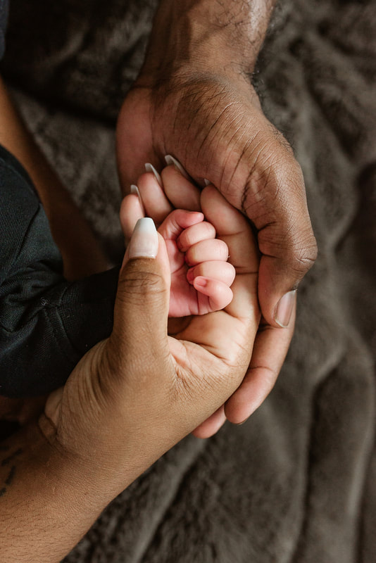 portrait of new parents holding hands with newborn baby in Memphis, TN